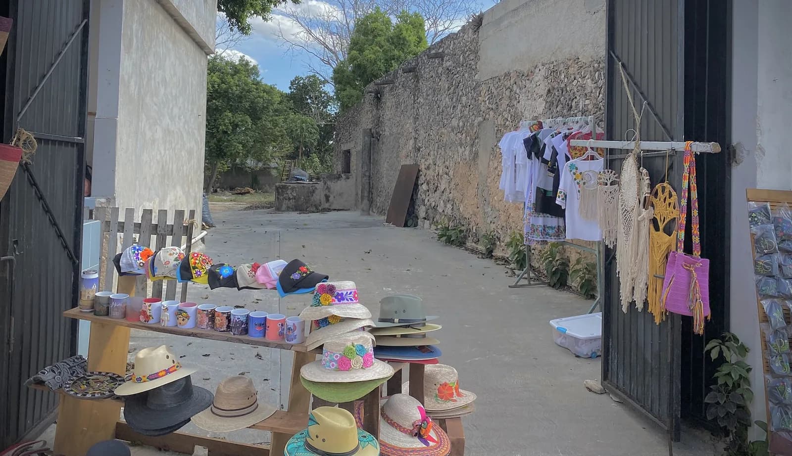 Sombreros, bolsas y blusas bordadas a la venta en la entrada de una casa de Maní, Yucatán