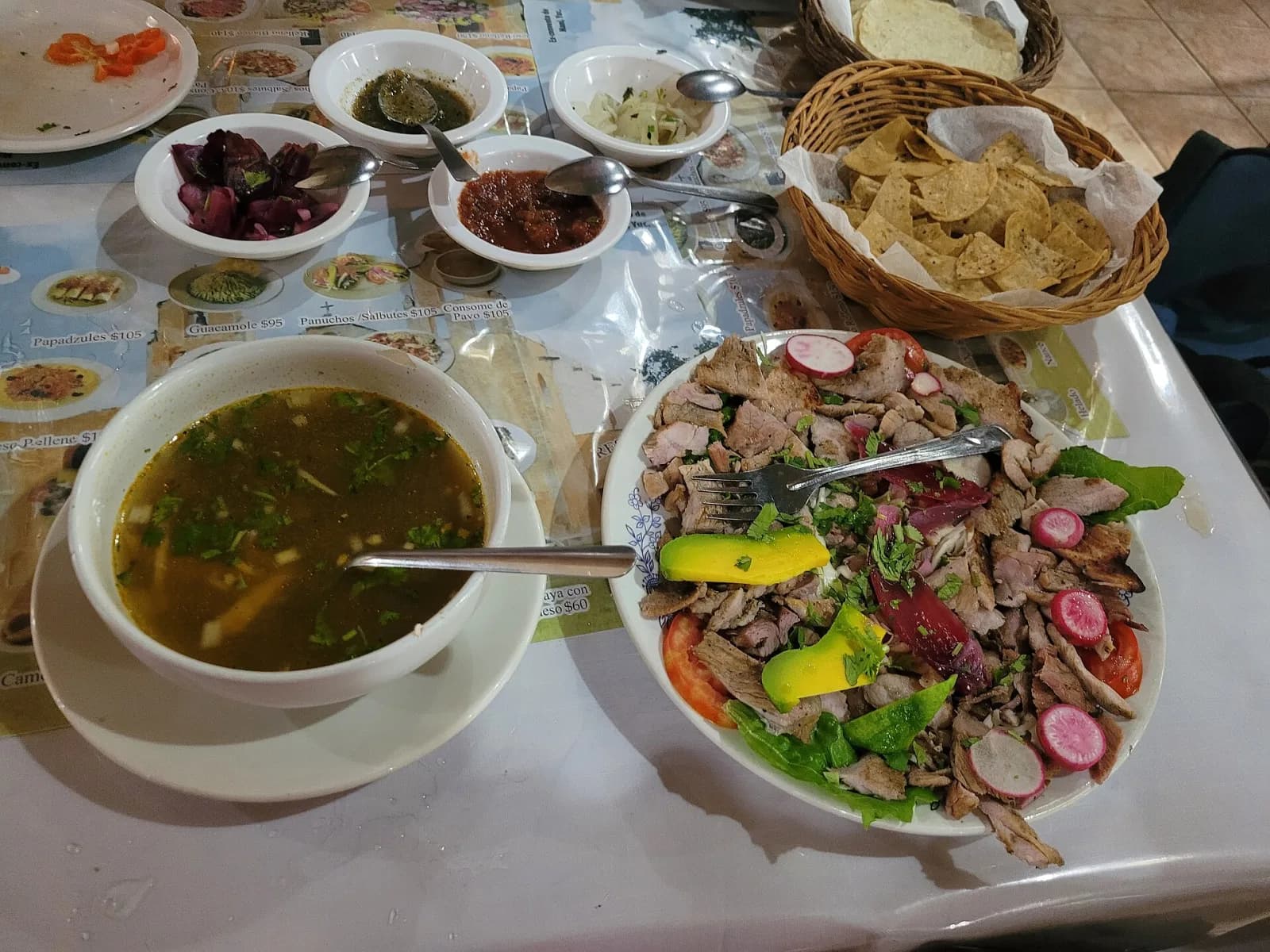 Sopa de lima y plato de poc chuc con aguacate, rábano y cebolla en un restaurante de Maní