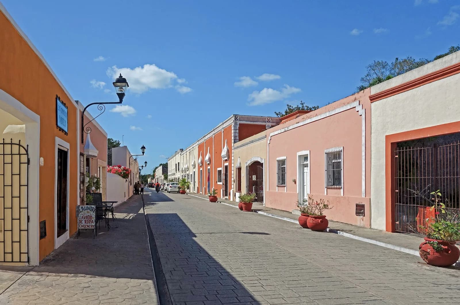 Calle empedrada con casas coloniales naranjas y rosas en el centro de Valladolid, Yucatán
