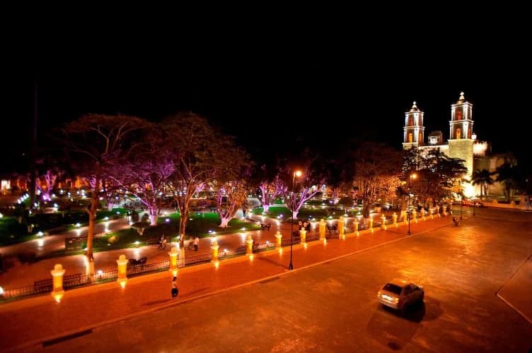 Parque principal de Valladolid iluminado de noche, con la iglesia de San Servacio al fondo