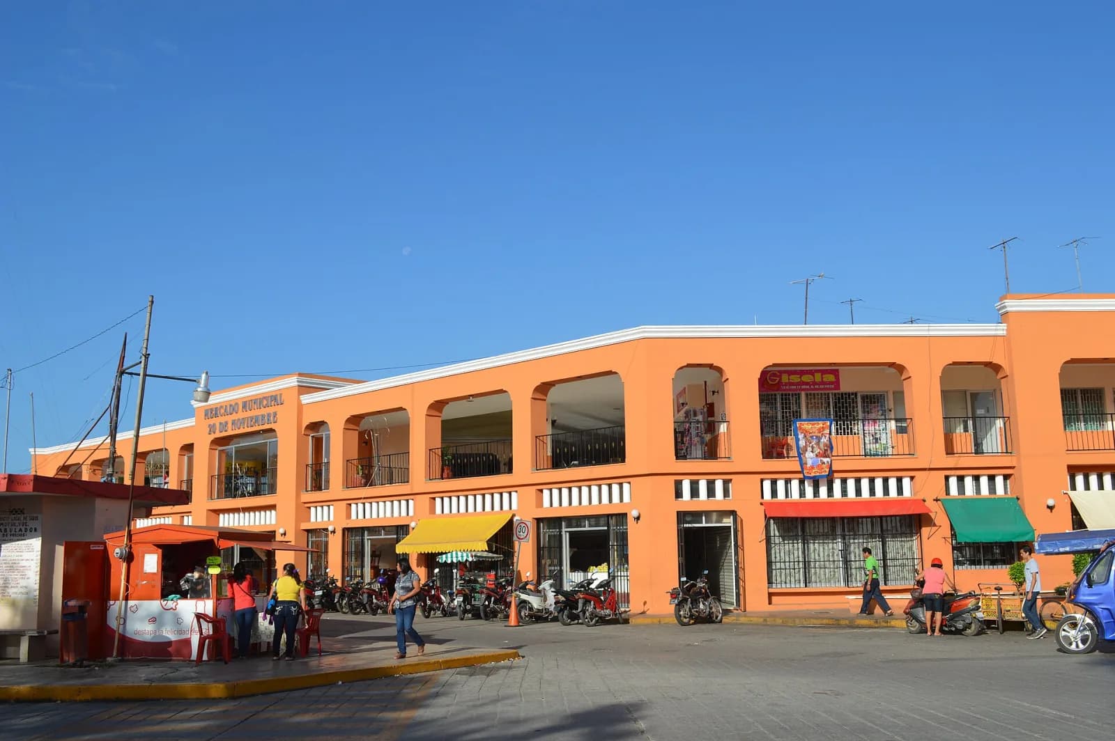 Mercado Municipal 20 de Noviembre de Motul, edificio naranja de dos pisos con portales