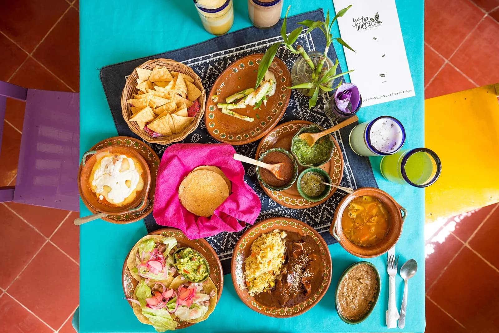 Mesa con platos de barro, salsas, tostadas y aguas frescas en Yerbabuena del Sisal, Valladolid