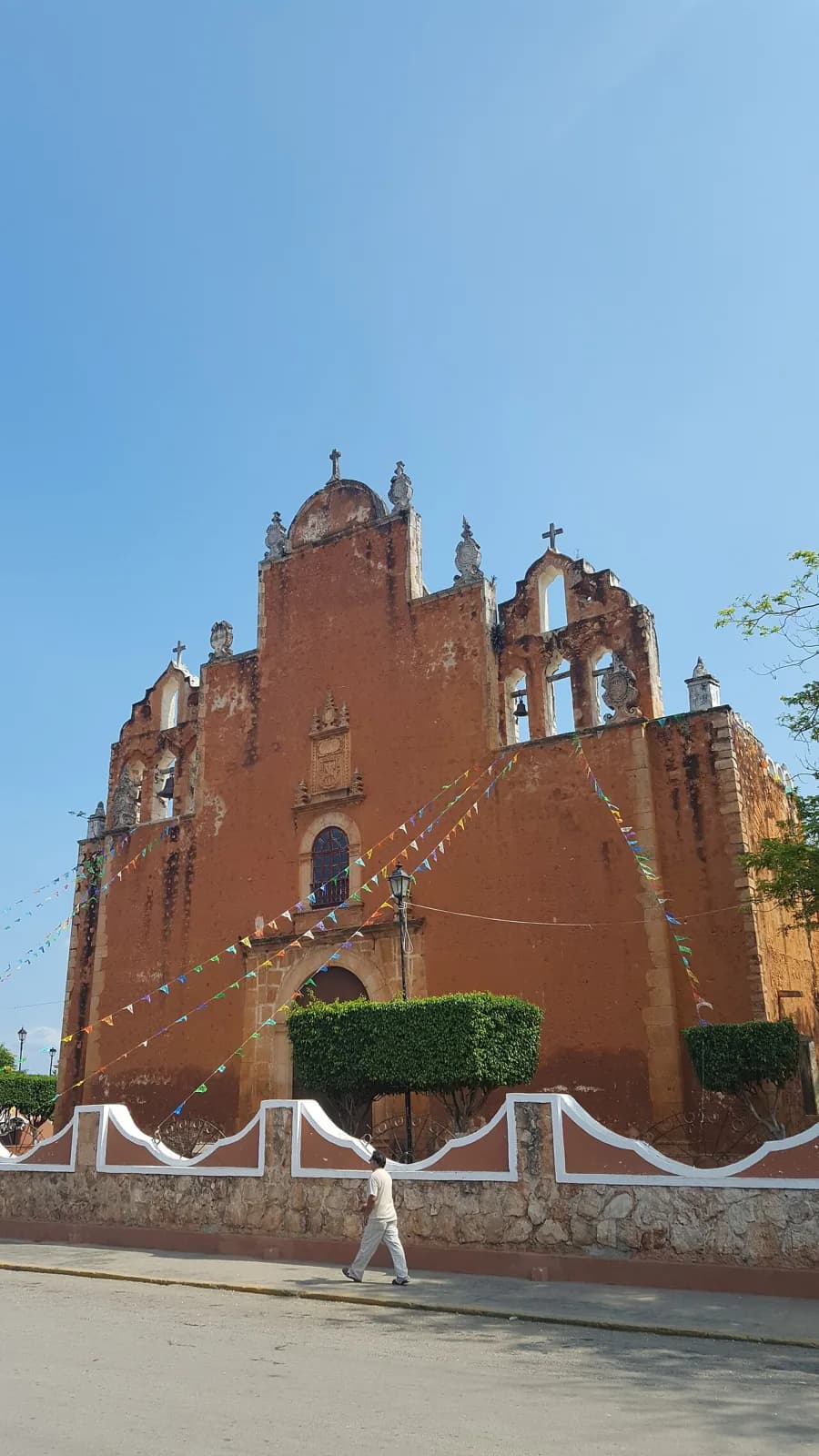 Parroquia de San Juan Bautista de Tekax vista desde la calle, con banderines de papel