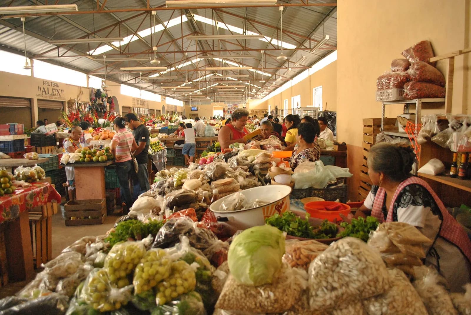 Puestos de verduras, frutas y chiles bajo el techo del mercado de Valladolid, Yucatán