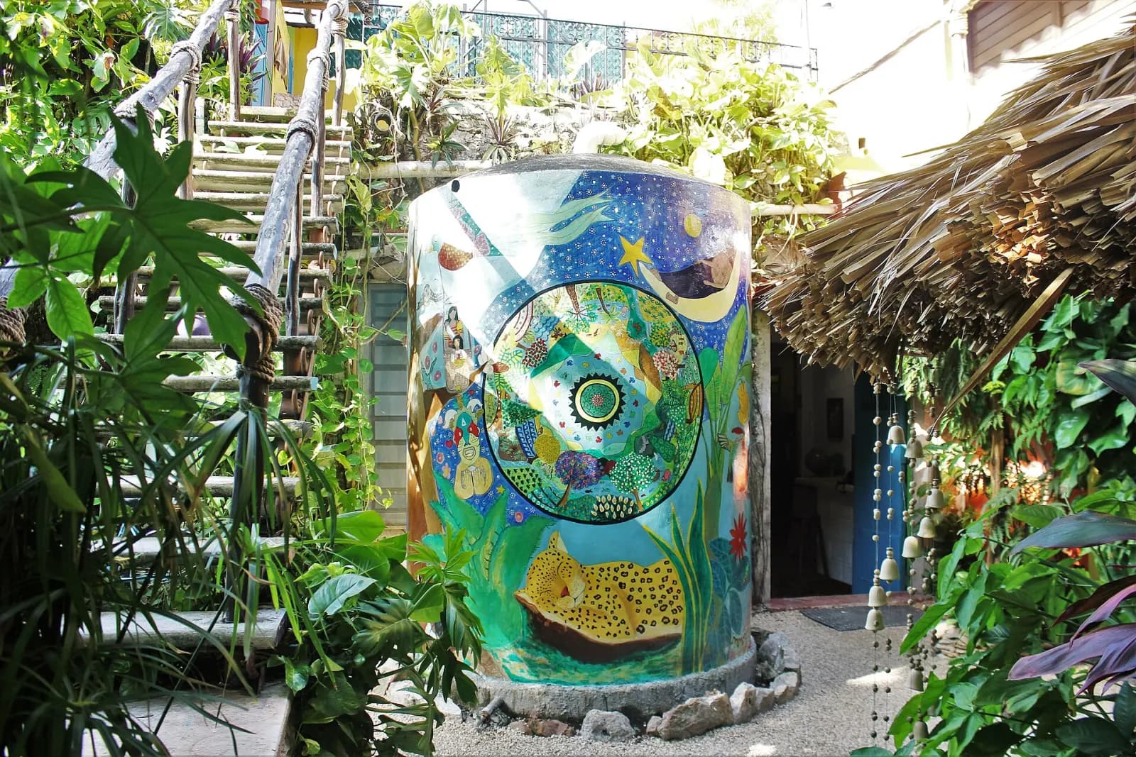 Tinaco pintado con mural de colores en el jardín del Hostel La Candelaria, Valladolid